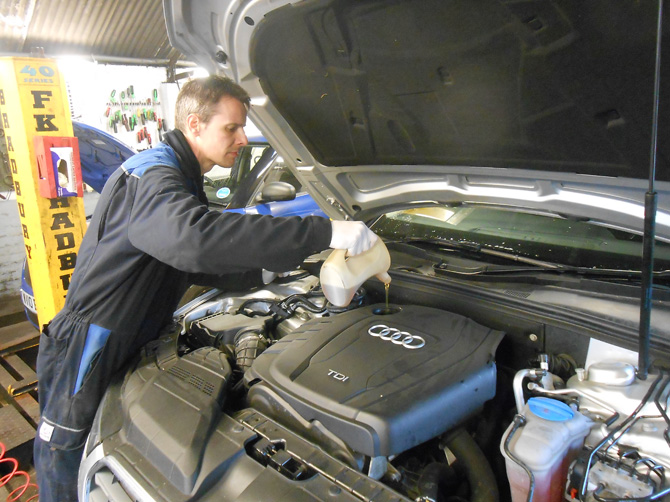 Mechanic working under the bonnet of an Audi at Golden Hill Garage