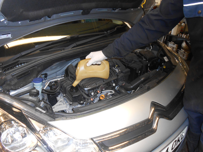 Mechanic working in the engine bay of a Citroën